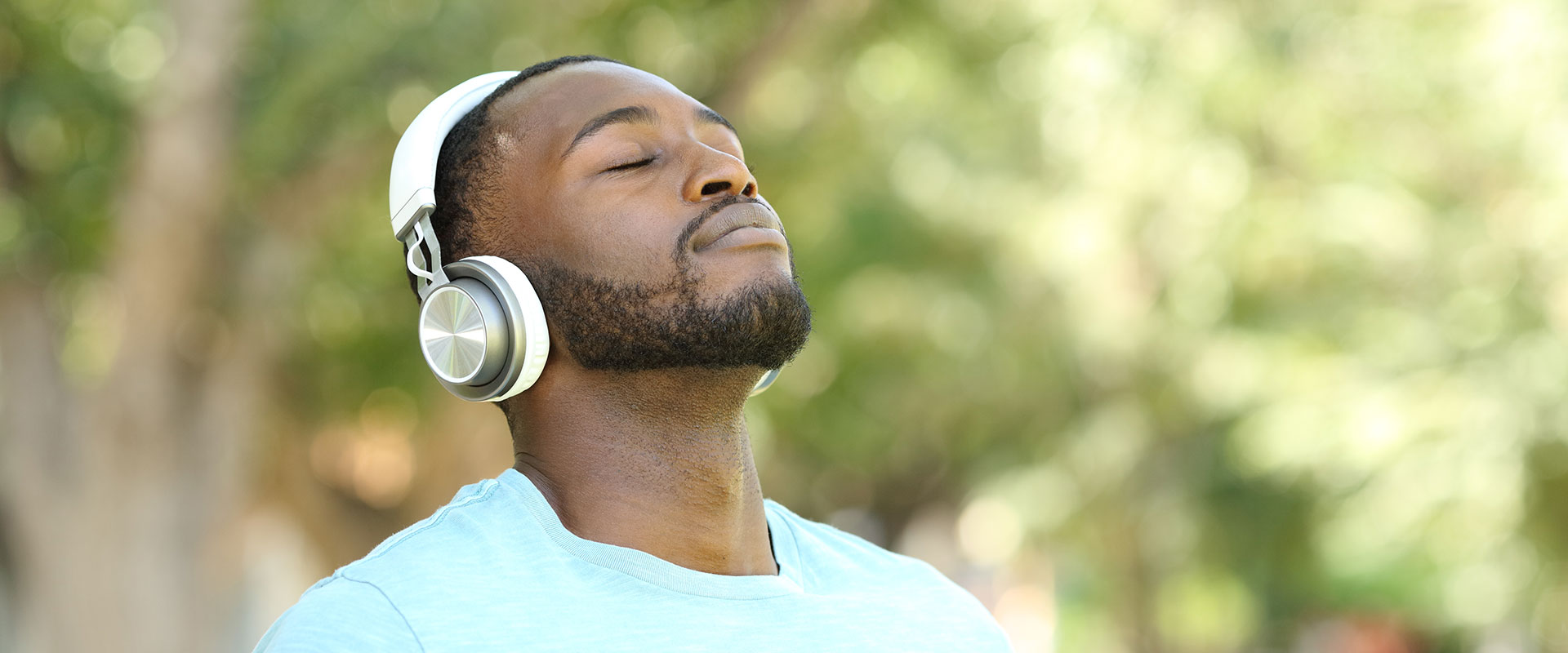 Man listening to music on over ear headphones outside