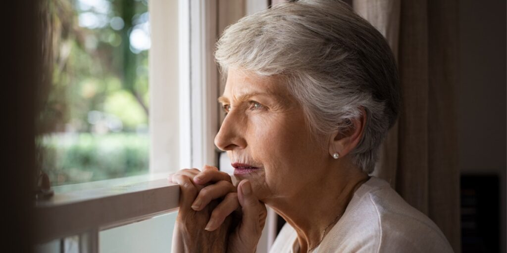 depressed senior woman at window