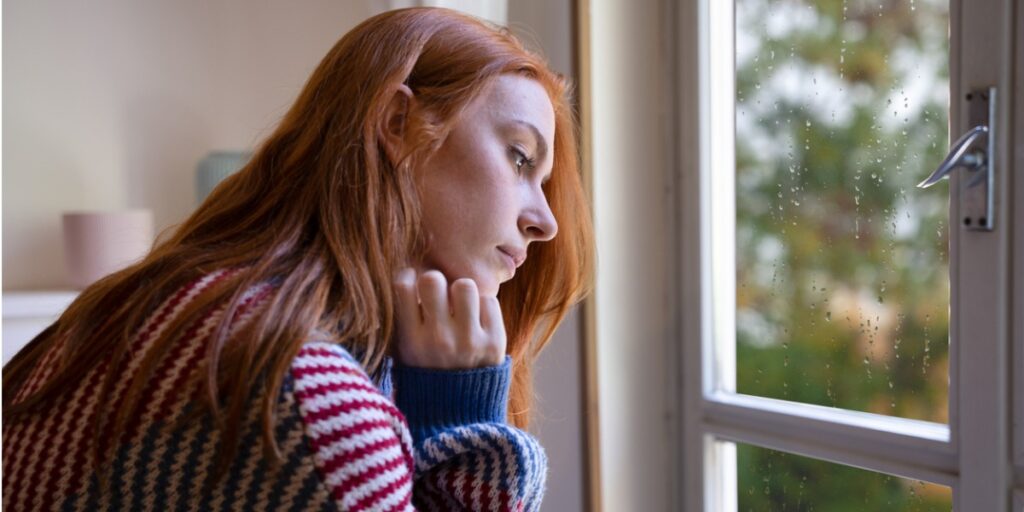 woman with seasonal depression looks out window