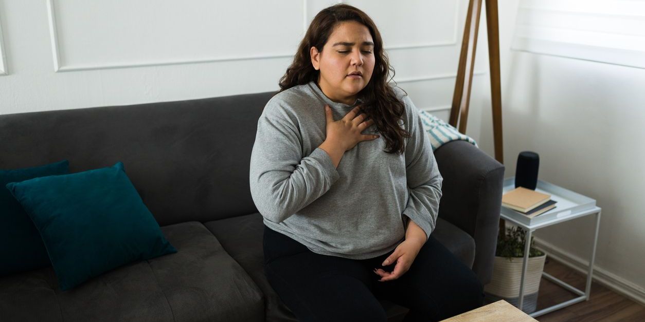 woman having panic attack sitting on couch