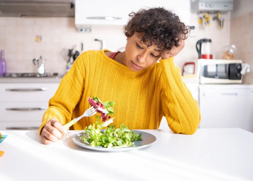 Woman trying to eat salad