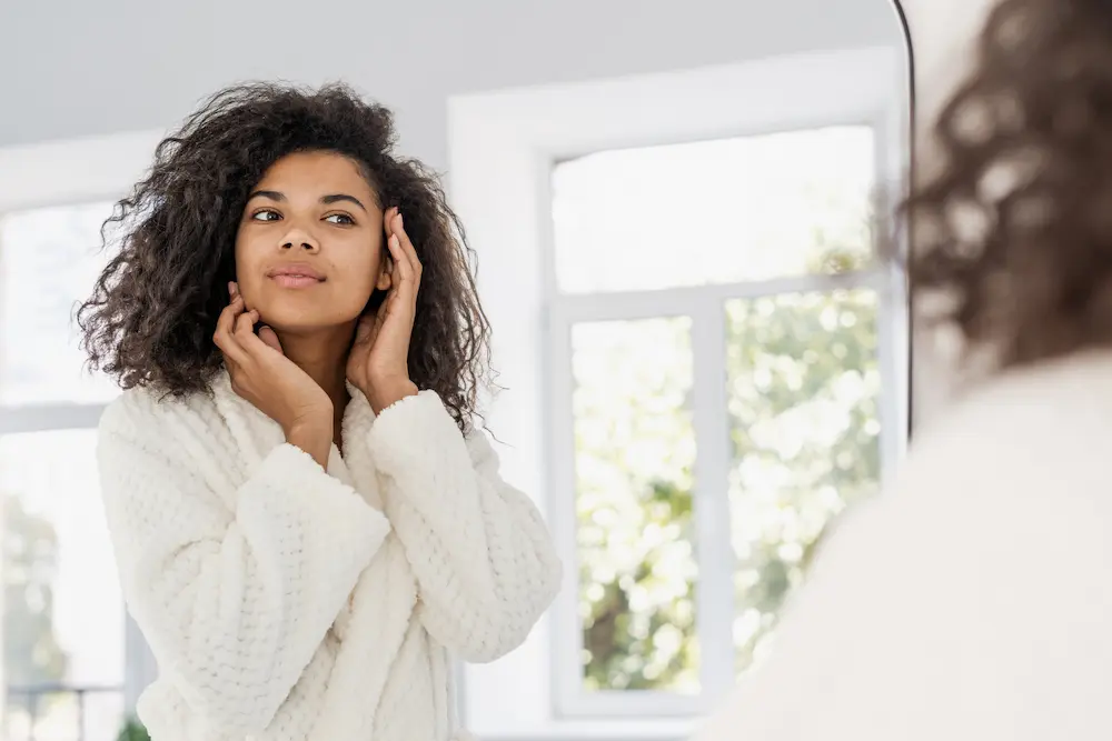 Young woman checking herself in mirror