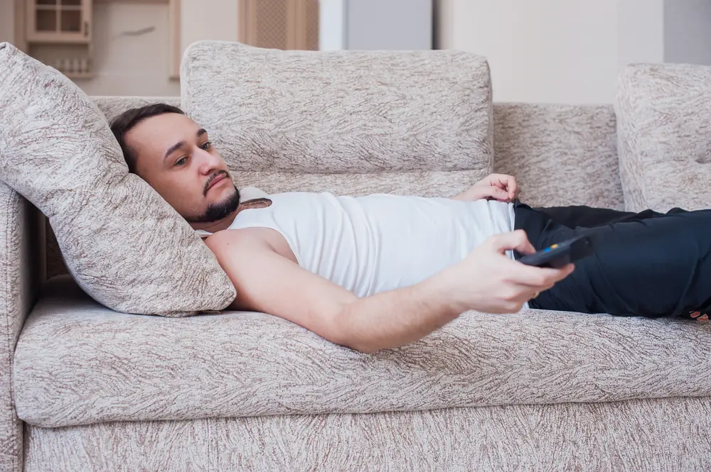 Man lying on couch depressed