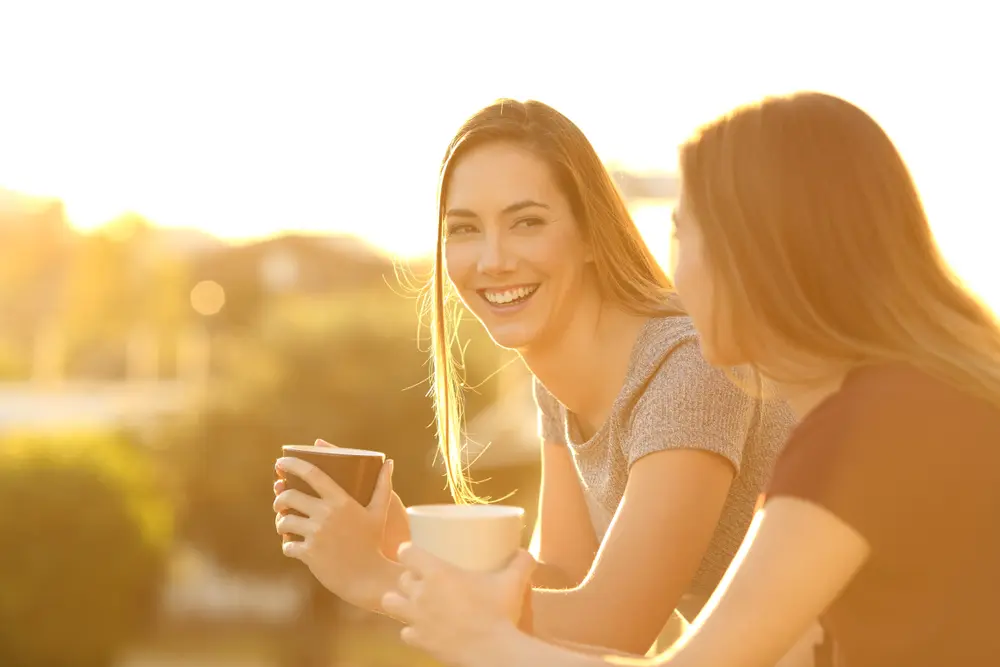 young women having coffee during sunrise