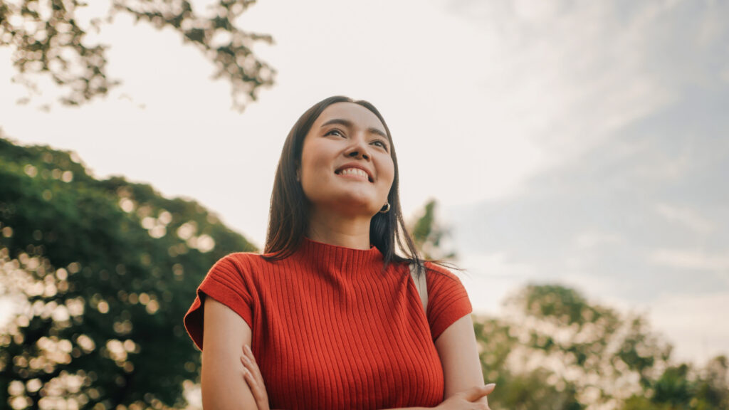 Smiling woman enjoying nature and freedom in sunny park setting