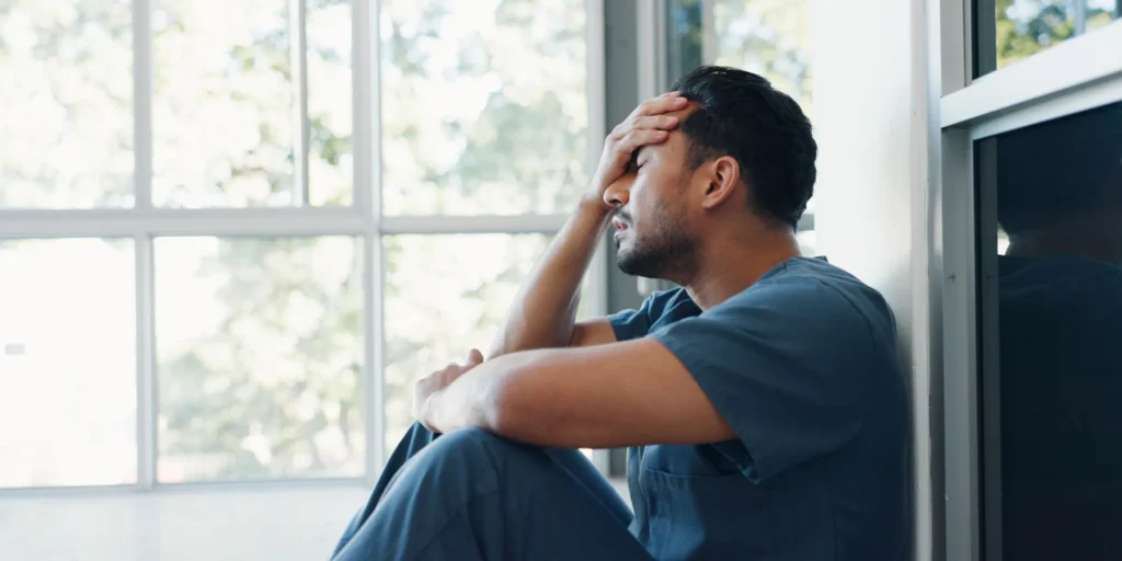 Man receiving depression treatment with a Deep TMS helmet in a mental health clinic.